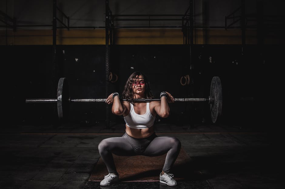 Image of a weightlifter gradually adding more weights to a barbell, representing the concept of progressive overloading.